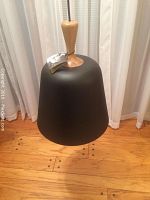 Full pendant lamp hanging showing black metal shade with natural wood top handle and black cord.