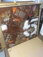 Full view of the large square iron art piece leaning inside a box, showing rust, painted number '5', and orange arrows.
