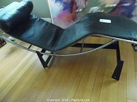 Side profile showing black leather upholstery and curved chrome-plated frame