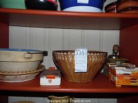 Shelf view of German pottery including pie plate, large bowl, and crockery items along with Austrian painted coffee mill and butter dish.