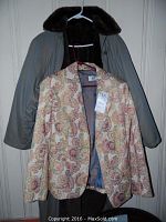 Raincoat and floral blazer hanging on door, showing full raincoat and front view of blazer