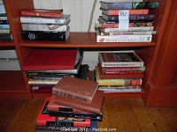 Photo of cookbooks stacked on shelves and floor, showing variety and condition of the set