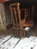 Front three-quarter view of forklift with forks lowered on snowy ground