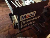 Front view of black metal service cart with Mobil Driveway Service branding showing tools inside.