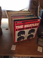 Side view of vinyl records arranged on a surface, showing the front cover of The Beatles' "A Hard Day's Night" album.