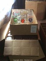 Box of clear glasses with various NFL team logos including Jets, Bengals, Bears, Dolphins