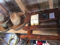 Photo of three straw cowboy hats and the wooden toy gun rack with the toy pistol attached, showing the arrangement of the items and the dimensions note (21x20).