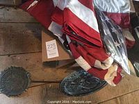Folded American flags with metal markers lying on wooden floor.