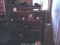 Front view of oak rack showing all four shelves and wheels under varied lighting