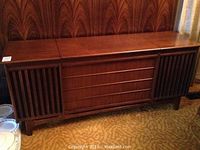 Closed view of entire wood veneer console showing speaker grilles and mid-century styling