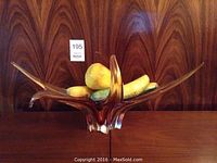 Amber colored decorative glass bowl shown holding fruit to display size and function.