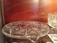 Clear crystal cake plate with detailed star and pinwheel cut pattern, 11.5-inch diameter.