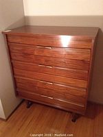 Front view of the entire dresser showing four aligned drawers and metal handles.