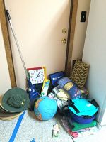 Full view of multiple household items including globe, pillows, aprons, folded fabric, and a blue Dirt Devil Broom Vac.