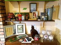 Overview of two wall-mounted shelves showing tins, trays, figurine, frames, baseball display cubes and assorted items