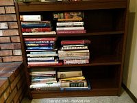 Wooden bookcase filled with multiple books showing shelf arrangement and wood finish.