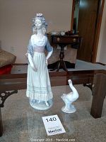 Photo showing both figurines on a glass table, full view including base and body posture.