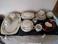 Full view of all ceramic and porcelain dinnerware including covered casseroles, platters, cream and sugar sets, and plates.