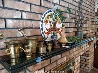 Side view of brass mortars and pestles with decorative items including vases and Dutch hex sign