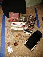 Full lot overview including jewelry, watches, cummerbunds, cuff links, and shoe bag on carpeted floor