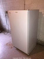 Front view of white upright freezer with Frigidaire Commercial logo.