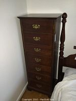 Front view of tall narrow chest showing six-drawer facade and brass bail handles