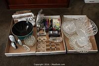 Wide view photo of various crystal and glass items arranged in three boxes including bowls, napkin rings, shakers, figurines, and smaller pieces.