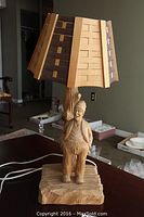 Front view of the lamp showing woodcutter figure, tree trunk base, and lampshade