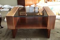 Front view of wood and glass side table showing glass inset top and shelf