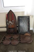The complete set showing brown leather wall art, wooden candle sconce with candles, and black decorated leather tray on carpeted floor near window.