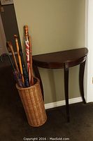 Table and wicker basket with umbrellas and canes showing full lot