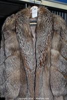Front view of three-quarter length fox fur coat hanging