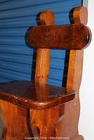 Photo showing the seat and back leg structure of the rustic pine chair with wood grain and signs of wear.