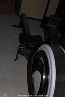 Full side view of rowing machine showing frame, rail and seat