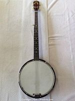 Front full view of the 5-string KAT banjo showing entire instrument with white banjo head and wooden neck.