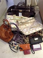 Overall view of handbags and wallets stacked together showing variety of brands and styles