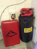 Overall view of punching bag, red arm block, boxing gloves, and Bruce Lee doll packed with the arm block.