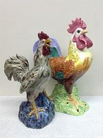 Both ceramic roosters side by side, showing size and color contrast