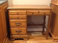 Full front view of the wooden study desk showing drawer configuration and condition.