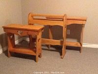 Photo of two wooden blanket rails placed on carpet against beige wall. Smaller rail with heart cutout and shelf on left, larger rail with rounded top on right.