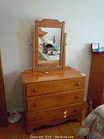 Front view of maple wood dresser with mounted mirror showing overall condition and design
