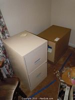 Photo showing Montgomery Ward combination safe with combination lock and keyhole, positioned next to the beige 2-drawer file cabinet.