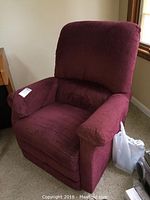 Front angle of the maroon rocking and reclining chair showing uplholstery and seat cushion.