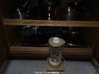 Photo showing two drawers filled with assorted pots and pans, and vintage Sears blender on the floor in front.