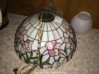 Overall view of stained glass hanging lamp fixture with chain attached, showing floral pattern.