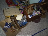 Overall lot overview showing multiple boxes of toys and storage trunk