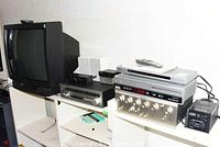 Wide shot showing JVC CRT TV, Kenwood amplifier, Sony CD player, Philips recorder and ABC transformer on shelf