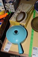 Braun electric crepe maker in original box next to blue sauce pan with lid