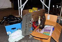 Wide view of the box showing cleaning supplies, hangers, and boxes with playing cards and pill divider