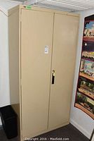Front view of beige metal storage cabinet with two closed doors and lock.